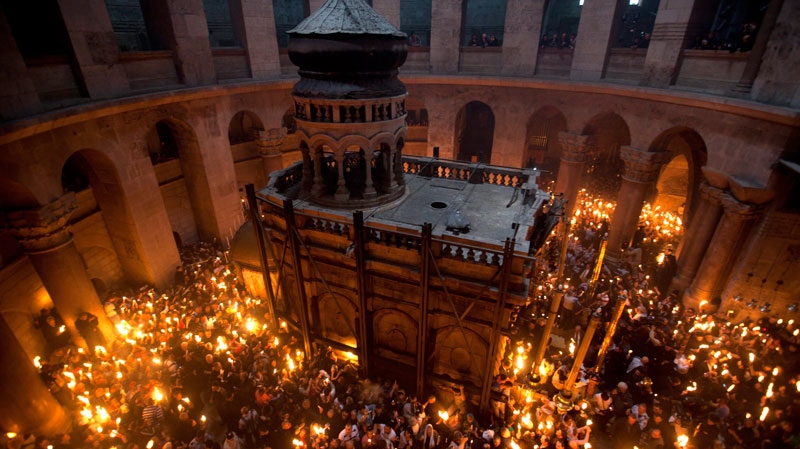 Christian Orthodox pilgrims light candles as fire spreads through the crowd attending the Holy Fire ceremony at the Church of the Holy Sepulcher in Jerusalem's Old City, Saturday, April 23, 2011. (AP / Oded Balilty)