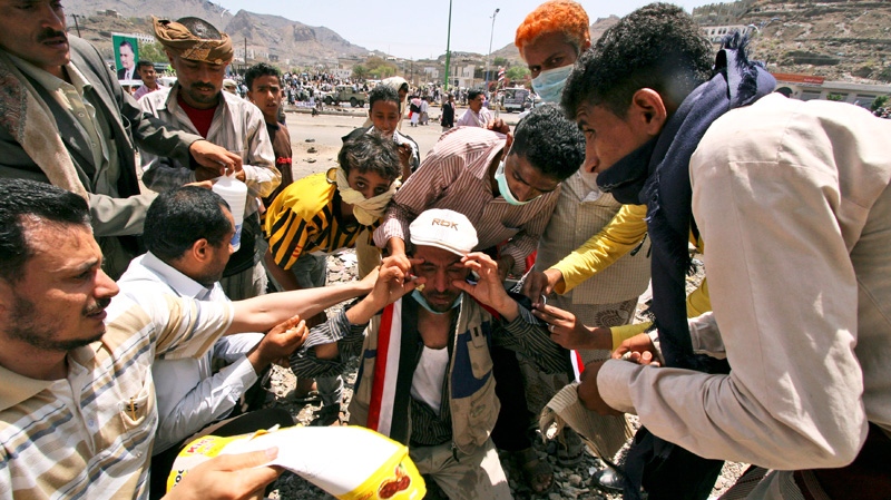 Anti-government protestors help a demonstrator suffering from the effects of tear gas fired by Yemeni security forces during clashes, in Taiz, Yemen, Monday, April 25, 2011. (AP / Anees Mahyoub)