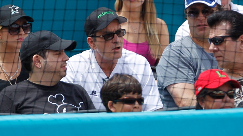 Charlie Sheen, centre, watches a baseball game between the Colorado Rockies and the Florida Marlins on Sunday, April 24, 2011, in Miami. (AP / J Pat Carter)