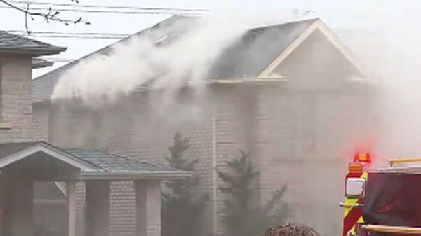 Smoke pours out of a burning Mississauga home where police say evidence of a grow-operation was discovered, Tuesday, April 26, 2011.