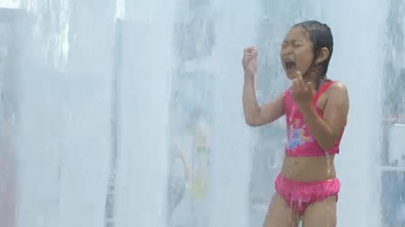 heat wave child in sprinkler