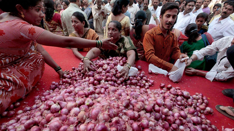 People try to grab onions being sold by a political party at cheap rates as a mark of protest against the rising prices in Mumbai, India, Sunday, Jan. 9, 2011. (AP / Rajanish Kakade) 