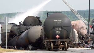 Fire fighters keep watering DOT-111 tanker cars railway cars the day after a train derailed causing explosions of railway cars carrying crude oil in Lac-Megantic, Que., Sunday, July 7, 2013. (Paul Chiasson / THE CANADIAN PRESS)