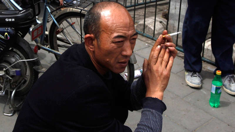 A man smokes on a street of Beijing, China, Sunday, May 1, 2011. (AP / Ng Han Guan)
