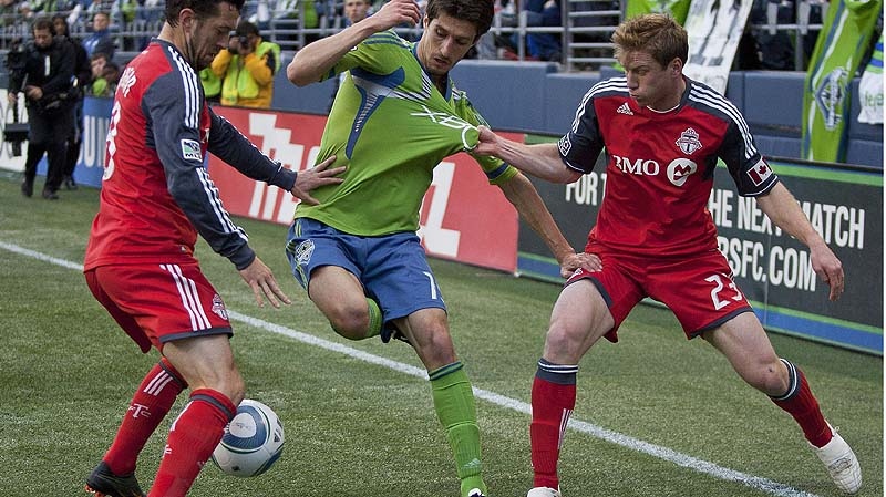 Toronto's Jacob Peterson, right, pulls on the jersey of Seattle's Alvaro Fernandez in the corner. At left is Toronto's Dan Gargan. Sounders FC take on Toronto FC on Saturday, April 30, 2011 at Qwest Field in Seattle, Wash. (AP PHOTO/The Seattle Times, Dean Rutz) 