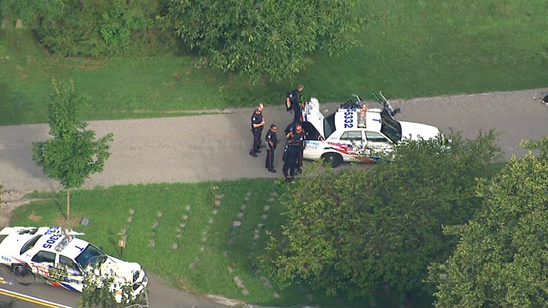 Officers are seen at Mount Pleasant Cemetery following a pursuit on foot, Wednesday, July 24, 2013.
