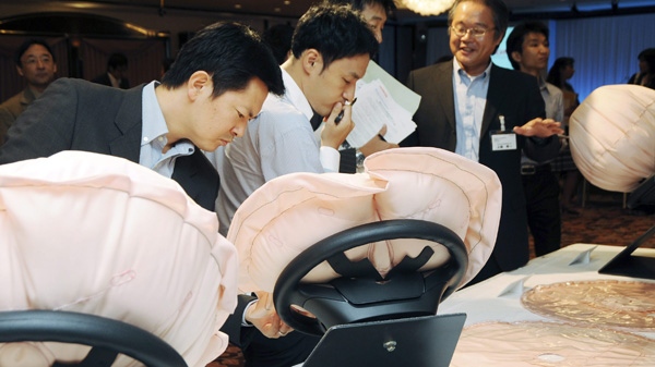 In this Thursday, Sept. 18, 2008 file photo, reporters take a close look at Honda Motor Co.'s newly-developed air bags on display in Tokyo. (AP Photo/Katsumi Kasahara)