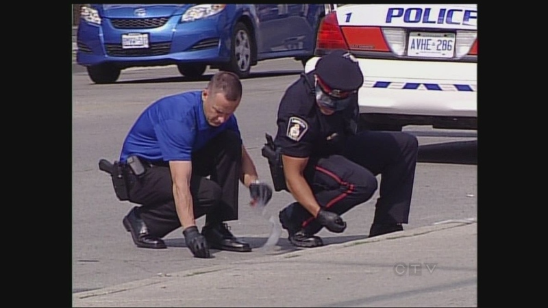 Investigators collect evidence after a stabbing in east London, Ont. on Thursday, July 25, 2013.