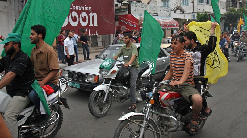 Palestinians ride motorcycles while waving yellow Fatah and green Hamas flags along the streets during a rally celebrating the planned signing of a reconciliation agreement between Fatah and Hamas, in Gaza city, Wednesday, May 4, 2011. (AP / Adel Hana)