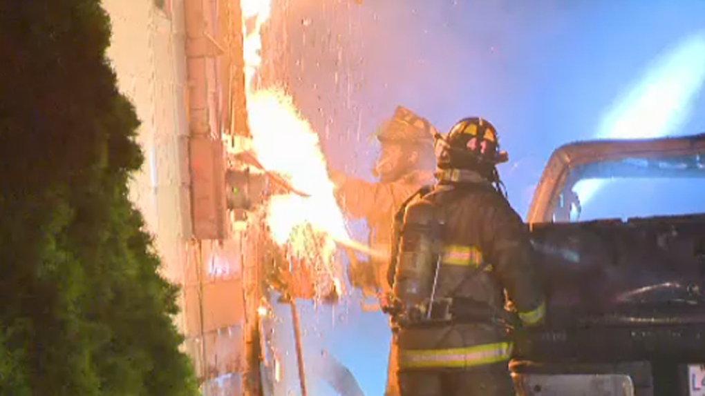 Firefighters try to extingish flames on house