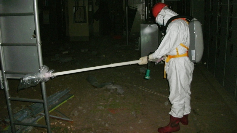 In this Thursday, May 5, 2011, photo released by Tokyo Electric Power Co. (TEPCO), a worker measures radiation levels inside the Unit 1 reactor building of the Fukushima Dai-ichi nuclear power plant in Okuma, Fukushima Prefecture, northeaster Japan. (AP / Tokyo Electric Power Co.)