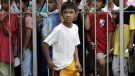 A newly circumcised boy walks past a line of other boys waiting to be circumcised during a free circumcision surgery Saturday, May 7, 2011, in Marikina city, east of Manila, Philippines. (AP Photo/Pat Roque)