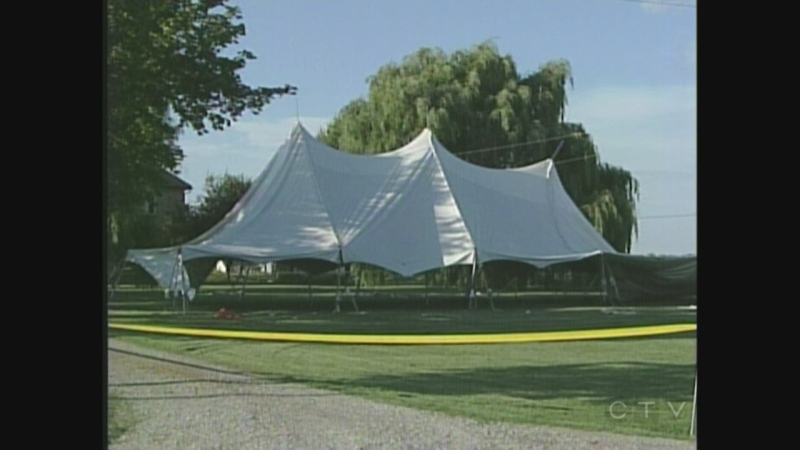 A partially set up tent where one man was killed and three injured is seen under hydro wires near Watford, Ont. on Thursday, Aug. 1, 2013.