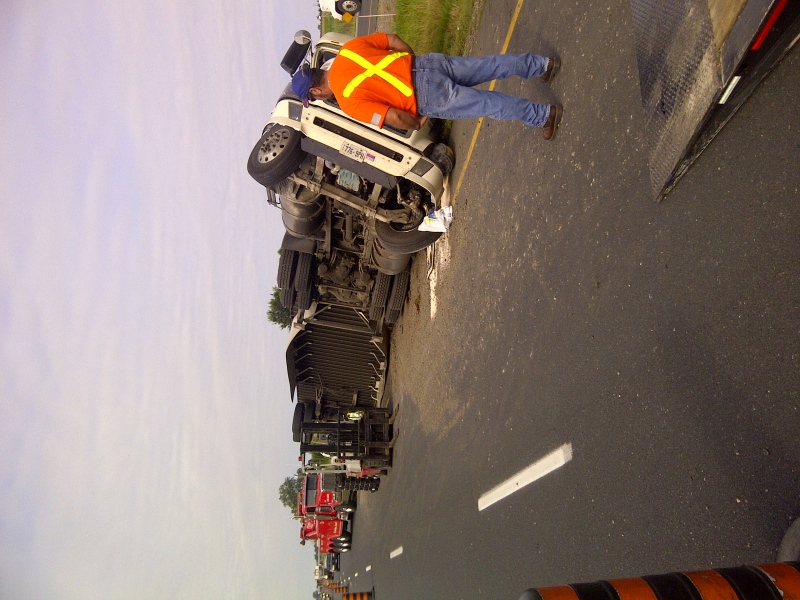 A tractor-trailer hauling auto parts that rolled on the eastbound Highway 401 in Chatham-Kent, Ont. early Thursday, August 8, 2013 is seen in this image provided by OPP Const. Aaron McPhail.