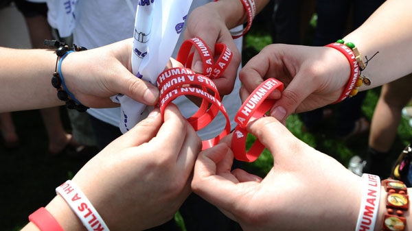 Anti-abortion protesters hand out bracelets as they take part in the March for Life on Parliament Hill in Ottawa on Thursday, May 12, 2011. THE CANADIAN PRESS/Sean Kilpatrick