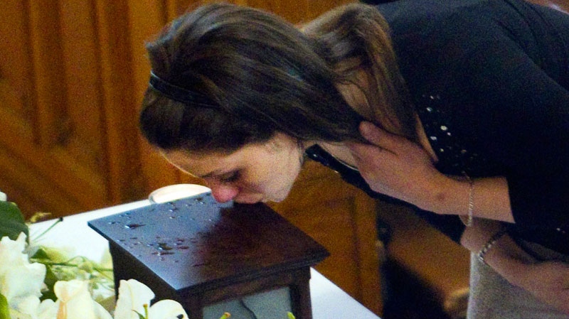 AndreAnn Riendeau kisses the urn of her sister Jolene Riendeau, during funeral services in Montreal, Friday, May 13, 2011. (Ryan Remiorz / THE CANADIAN PRESS)