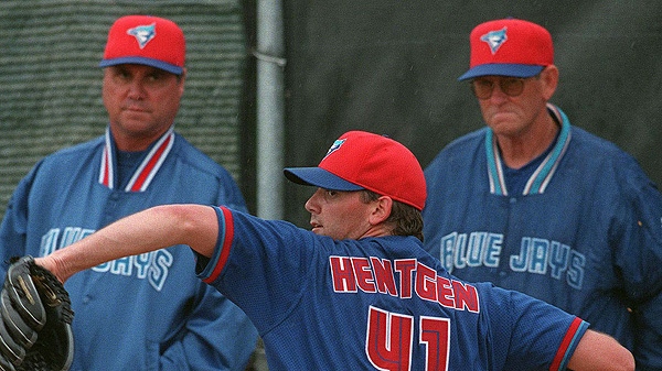 Toronto Blue Jays pitcher Pat Hentgen falls under the watchful gaze of manager Tim Johnson (Left) and pitching coach Mel Queen as he throws in the rain at Jays Spring Training camp in Dunedin, Fla., Wednesday March 3, 1999.(CP PHOTO/Frank Gunn)
