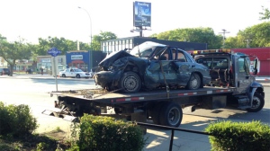 Crews clear the vehicle from the crash scene on Portage Avenue on Wednesday morning.