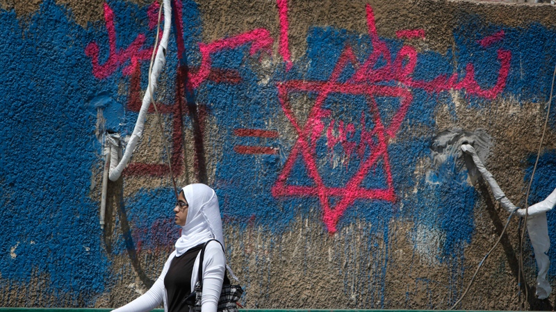 An Egyptian woman walks past an anti Israel graffiti with Arabic that reads 'Down with Israel' near the Israeli embassy in Cairo, Egypt Monday, May 16, 2011. (AP / Nasser Nasser)