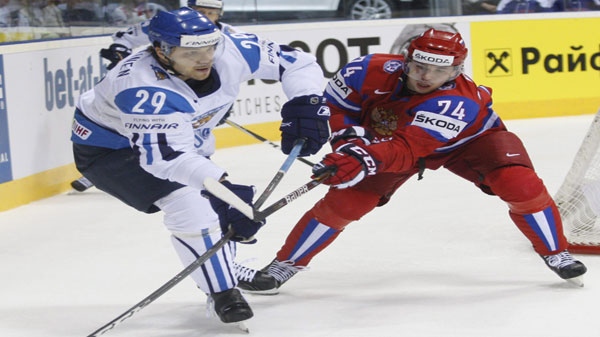 Finland's Petteri Nokelainen, left, fights for a puck with Alexei Yemelin, right, from Russia during their semifinal Hockey World Championships match in Bratislava, Slovakia, Friday, May 13, 2011. (AP Photo/Petr David Josek)