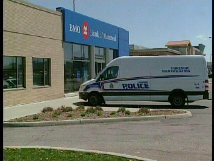 Police investigate a robbery at a Bank of Montreal on Commissioners Road in London, Ont. on Thursday, May 9, 2013.