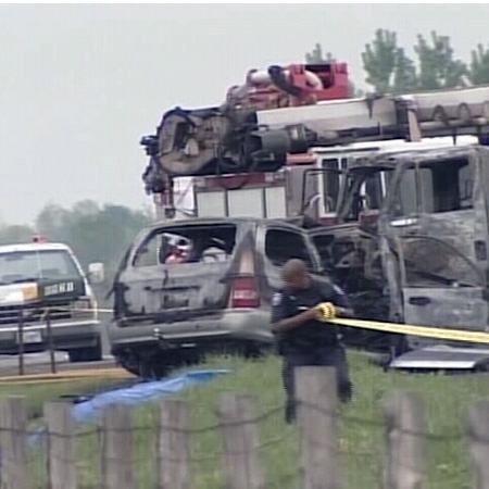 The remains of a burned minivan and utility truck sit on the side of a road in Ottawa's east end after a fatal two-vehicle collision, Monday, May 26, 2008.