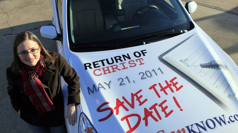 FILE - In this Dec. 17, 2010 file photo, Allison Warden poses with her car in Raleigh, N.C., showing a message about the rapture. Warden has been helping organize a campaign using billboards, post cards and other media in cities across the U.S. through the website We Can Know. (AP Photo/Gerry Broome, File)