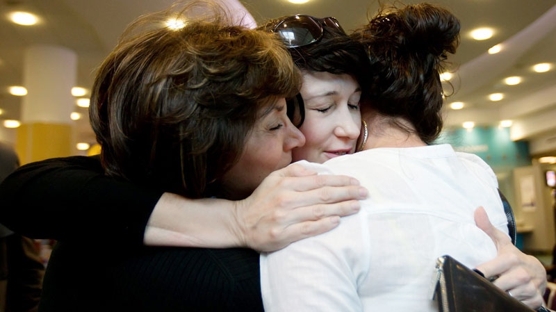 Journalist Dorothy Parvaz, centre, hugs her stepmother, left, and her sister Sheila, right, after arriving in Canada at Vancouver International Airport in Richmond, B.C., on Thursday May 19, 2011. (Darryl Dyck / THE CANADIAN PRESS)