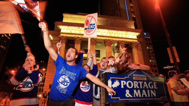 Hockey fans celebrate at Portage and Main in downtown Winnipeg after reading a report in The Globe and Mail newspaper that a NHL team maybe returning to Winnipeg, Thursday, May 19, 2011. (John Woods / THE CANADIAN PRESS)