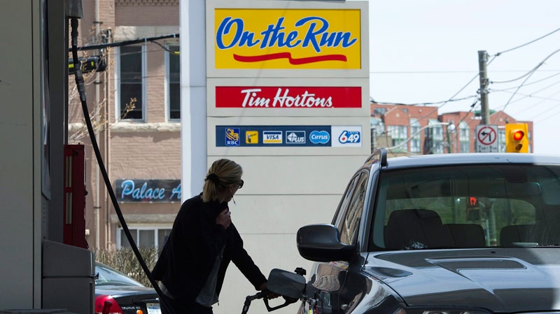 A woman pumps gas in Toronto on Tuesday, May 10, 2011. (Nathan Denette / THE CANADIAN PRESS)