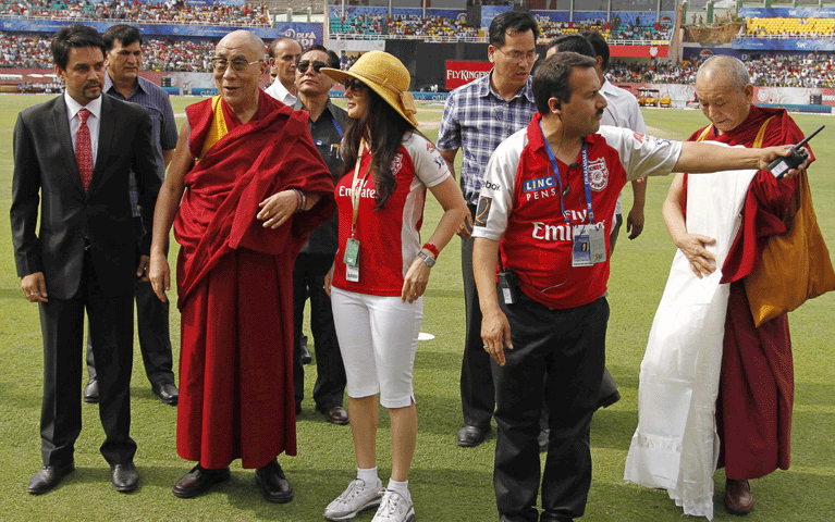 Tibetan spiritual leader the Dalai Lama, third left, stands next to Preity Zinta, center, owner of Kings XI Punjab team, before an Indian Premier League (IPL) match between Deccan Chargers and Kings XI Punjab in Dharmsala, India, Saturday, May 21, 2011. (AP / Ashwini Bhatia)