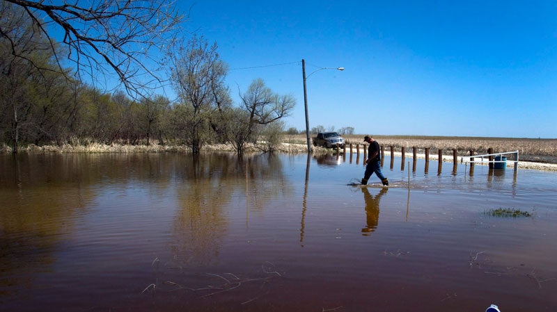 Peter Bradley walks through the floodwaters in front of his home in Twin Beach, Manitoba, Wednesday, May 18, 2011. (Ryan Remiorz / THE CANADIAN PRESS)