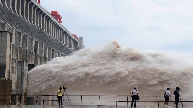 In this photo released by China's Xinhua news agency, journalists take photos as flood water is released from the Three Gorges Dam's floodgates in Yichang, in central China's Hubei province, Tuesday, July 20, 2010. (AP / Xinhua, Cheng Min, File) 