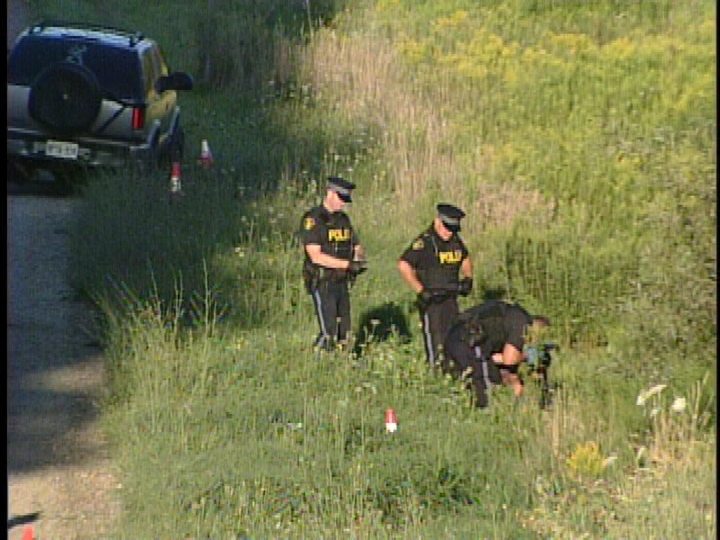 Police investigate at the scene of a fatal collision between an SUV and bicycle near Aylmer, Ont. on Saturday, August 24, 2013.