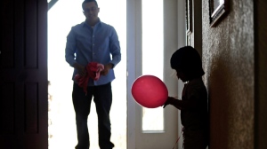 Mireya Salazar stares at a pink balloon as her father Nelson waits for her in the doorway of his parents' house in Denver on Wednesday, March 30, 2011. (AP / The Denver Post, AAron Ontiveroz)