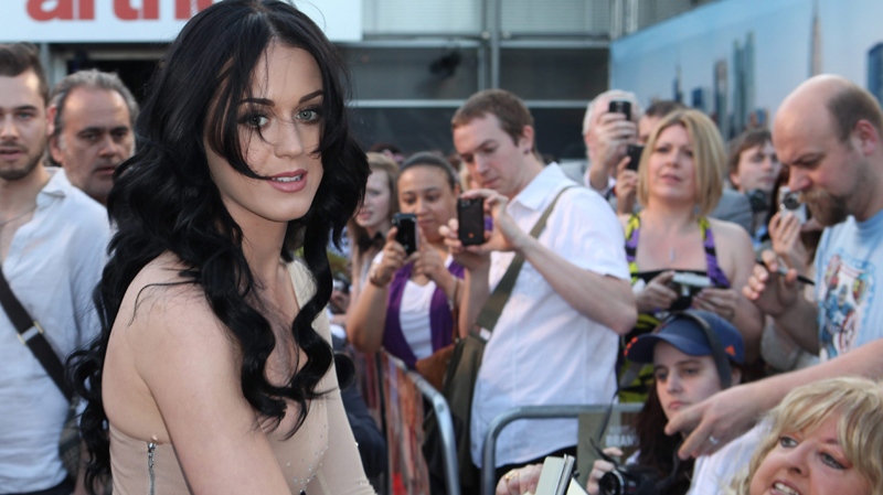 Katy Parry signs autographs as she arrives for the European premiere of Arthur, in London, Tuesday, April 19 2011. (AP / Joel Ryan)