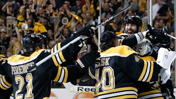 Boston Bruins players including defenseman Zdeno Chara, face showing, celebrate around goalie Tim Thomas after they defeated the Tampa Bay Lightning in Game 7 of an NHL hockey Stanley Cup playoffs Eastern Conference final series in Boston, Friday, May 27, 2011. The Bruins won 1-0. (AP Photo/Elise Amendola)