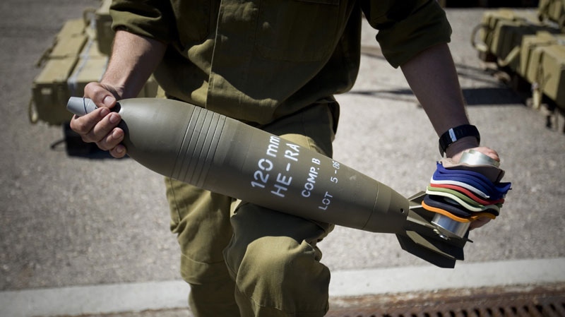 In this March 16, 2011 file photo, an Israeli soldier holds a 120mm mortar shell seized from the Victoria cargo ship that was intercepted by Israel in the Mediterranean Sea, in the port of Ashdod, Israel. (AP Photo/Ariel Schalit, Files)