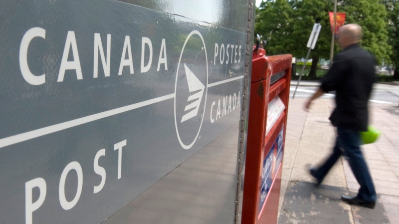 A man walks past Canada Post mail boxes in Ottawa, Monday, May 30, 2011. Canada Post's union announced they had given 72-hour strike notice. (Adrian Wyld / THE CANADIAN PRESS)  