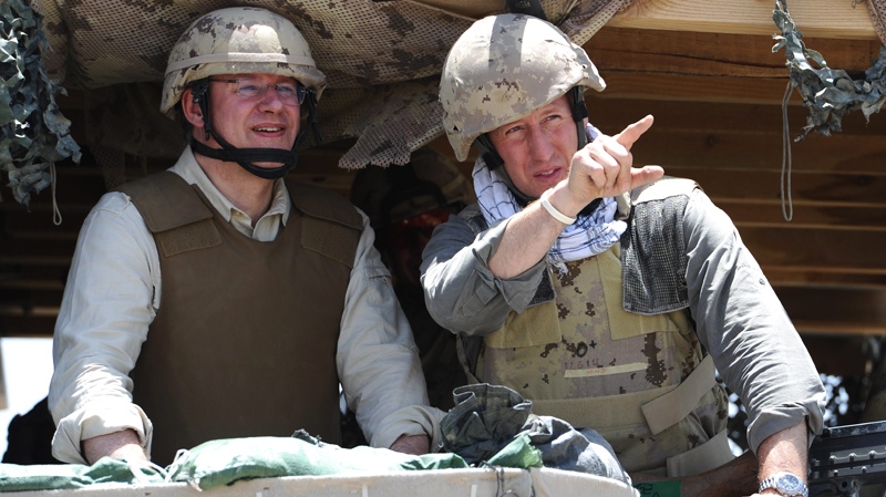 Prime Minister Stephen Harper, left, and Minister of Defence Peter MacKay look out from a bunker as the visit a forward operating base in the district of Sperwan Ghar, Afghanistan on Monday, May 30, 2011. (Sean Kilpatrick / THE CANADIAN PRESS)
