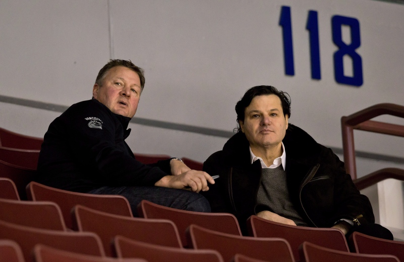 Vancouver Canucks' general manager Mike Gillis, left, and owner Francesco Aquilini watch players practice on the first day of the NHL hockey team's training camp in Vancouver, B.C., on Sunday January 13, 2013. THE CANADIAN PRESS/Darryl Dyck
