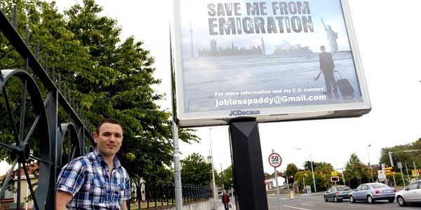 Feilim Mac An Iomaire stands next to a billboard he paid for in Dublin, Wednesday June 1, 2011.