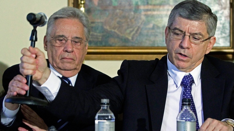 Members of the Global Commission on Drug Policy, Fernando Henrique Cardoso, left, former President of Brazil and the commission's chairman, hands over a microphone to Cesar Gaviria, former President of Colombia, during a news conference at the Waldorf Astoria in New York on Thursday, June 2, 2011. (AP / Bebeto Matthews)
