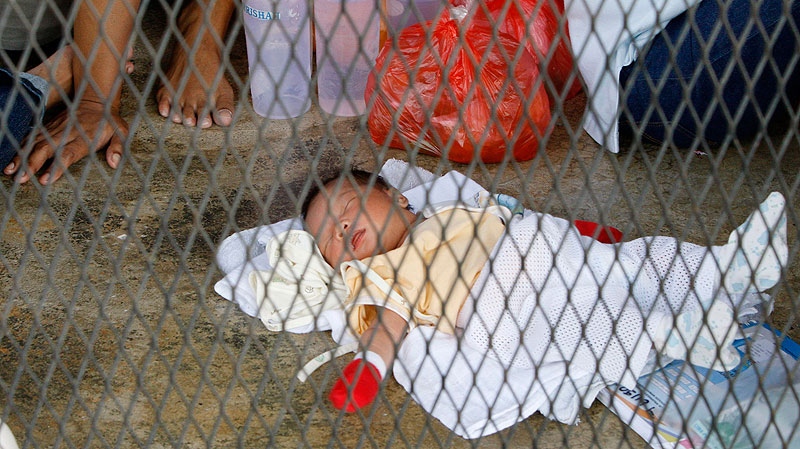 In this file photo, a baby sleeps on a concrete floor at a detention center on the outskirts of Kuala Lumpur, Malaysia, July 23, 2009. (AP / Mark Baker, File)