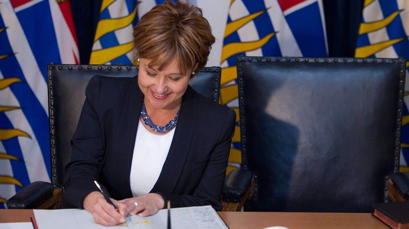 B.C. Premier Christy Clark signs records at her swearing-in as a member of the Legislative Assembly for Vancouver-Point Grey at the Legislature in Victoria, B.C. on Monday, May 30, 2011. (Arnold Lim / THE CANADIAN PRESS)