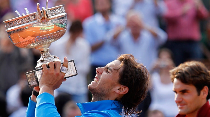 Spain's Rafael Nadal holds the cup after defeating Switzerland's Roger Federer, right, in the men's final match for the French Open tennis tournament at the Roland Garros stadium, Sunday, June 5, 2011, in Paris. (AP / Lionel Cironneau)