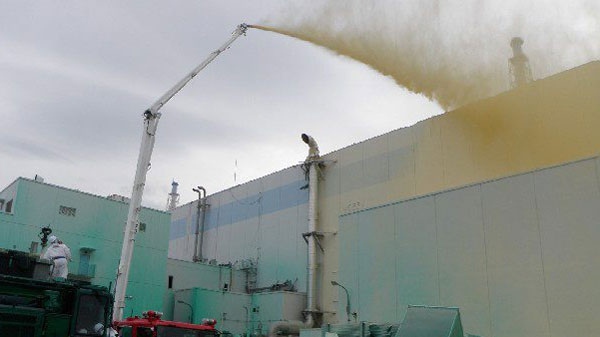 In this Friday, May 27, 2011, photo released by Tokyo Electric Power Co., workers spray a substance to prevent radioactive materials from spreading out from the Unit 1 area at the Fukushima Dai-ichi nuclear complex in Okuma, Fukushima Prefecture, northeastern Japan. (AP / Tokyo Electric Power Co.)