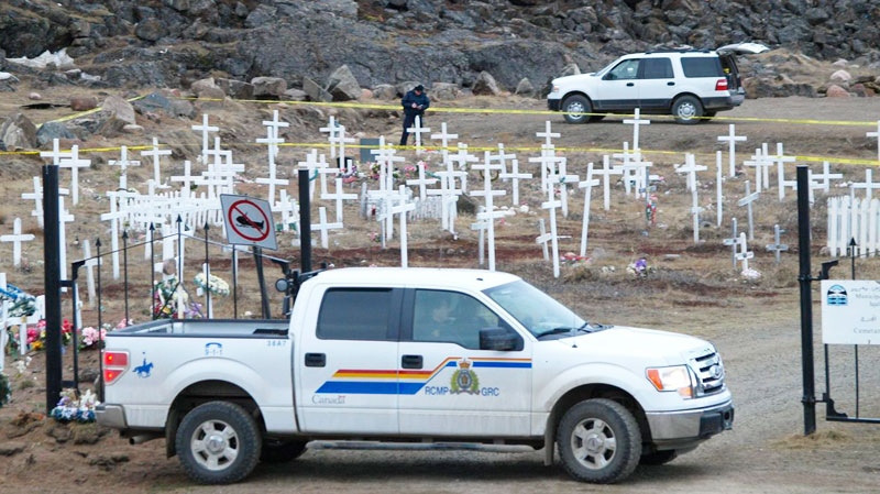 An RCMP investigator examines the area in Iqaluit's cemetery where the body of a man was found alongside a shotgun Tuesday, June 7, 2011. (Nunatsiaq News-Chris Windeyer)