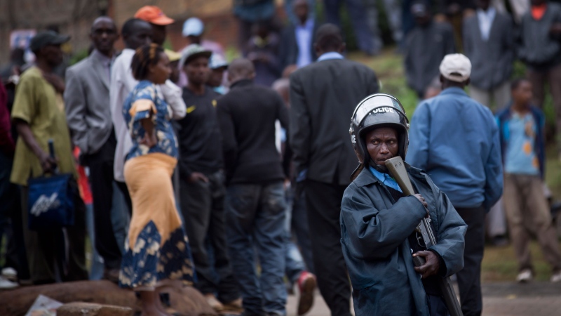 A Kenyan policeman keeps crowds of onlookers back from the Westgate Mall, in Nairobi, Kenya, Monday, Sept. 23, 2013. (AP / Ben Curtis)