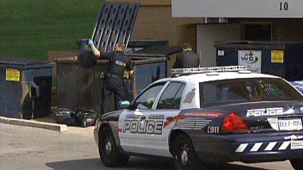 Waterloo Regional police officers search dumpsters outside 10 Overlea Drive in Kitchener, Ont. on Friday, June 10, 2011.